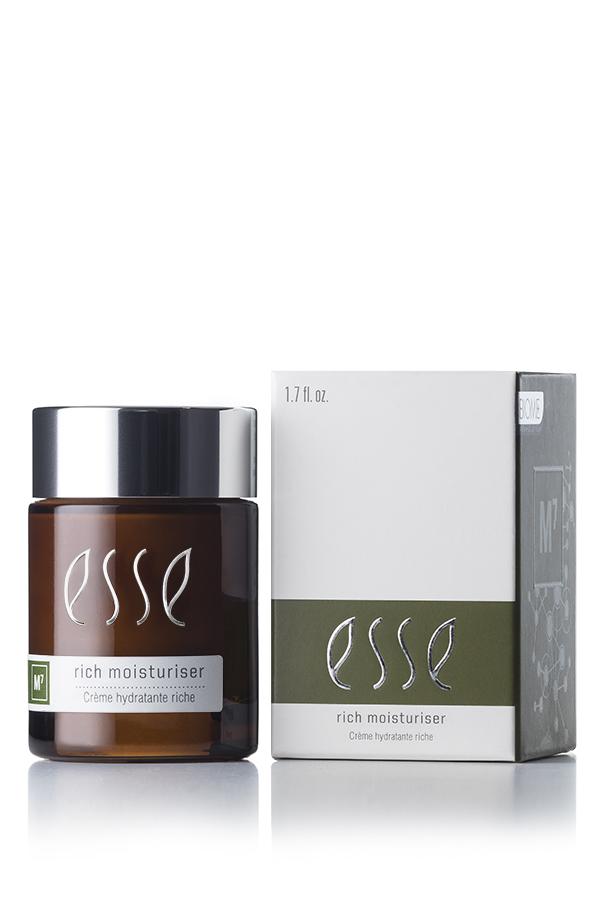 A 50ml brown glass jar of Esse Rich Moisturiser with a silver cap is placed next to its corresponding box. Both the jar's label and the box display the brand name "Esse" along with product information in white and green text.