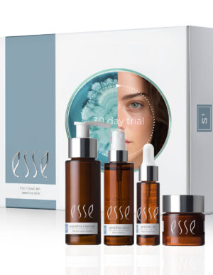 The Esse Sensitive Skin Trial / Travel Set includes four brown glass bottles: a cleanser, mist, serum, and cream. The white packaging behind features the brand name 'Esse' and an image of a woman’s face with '30 Day Trial' text.