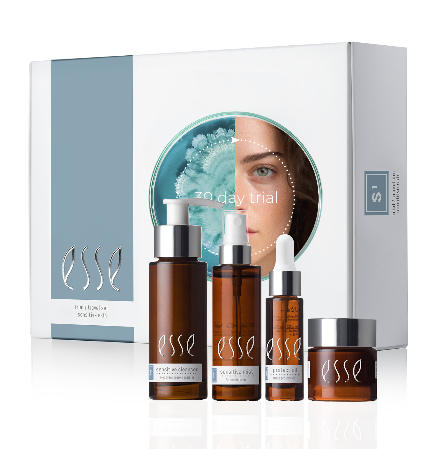 The Esse Sensitive Skin Trial / Travel Set includes four brown glass bottles: a cleanser, mist, serum, and cream. The white packaging behind features the brand name 'Esse' and an image of a woman’s face with '30 Day Trial' text.