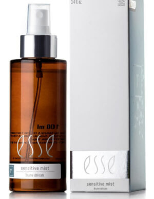 A brown bottle labeled "Esse Sensitive Mist" with a silver pump dispenser is positioned next to a matching white box. The box displays "3.4 fl oz" at the top and "Sensitive Mist" and "Brume Délicate" at the bottom. The packaging features a minimalist design.