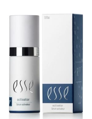 A cylindrical bottle with a metallic cap labeled "Esse Activator Sérum Activateur" is positioned next to its matching box. The box features a blue band at the bottom, showcasing the same text along with a subtle molecular graphic design on the side.